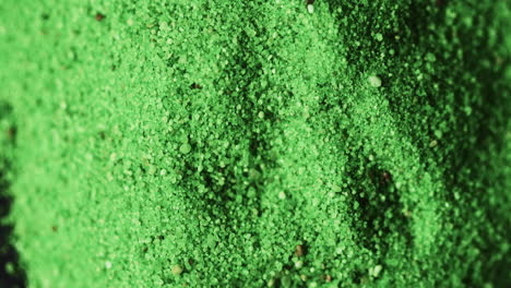 Video-of-close-up-of-green-powder-with-copy-space-on-black-background