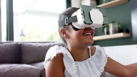 Happy-african-american-girl-in-vr-headsets-using-virtual-interface-at-home,-copy-space,-slow-motion