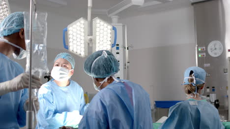 Diverse-female-surgeons-operating-on-patient-in-operating-theatre,-slow-motion