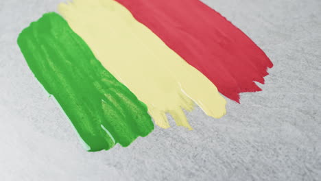 Video-of-red,-yellow-and-green-paint-smudges-with-copy-space-on-grey-background