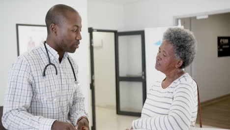Afroamerikanischer-Arzt-Im-Gespräch-Mit-Einer-älteren-Frau-Im-Krankenhaus,-Zeitlupe