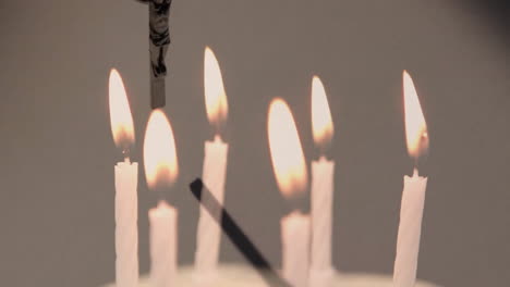 Animation-of-rosary-over-burning-candles-on-white-background