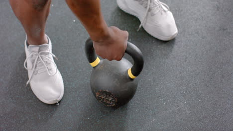 Fit-African-American-man-grips-a-kettlebell-at-the-gym