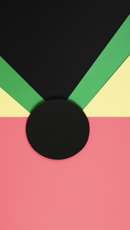 Vertikales-Video-Von-Roten,-Gelben-Und-Grünen-Papieren-Mit-Kopierraum-Auf-Schwarzem-Hintergrund