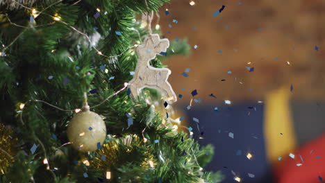 Animation-of-confetti-falling-over-christmas-tree-with-baubles
