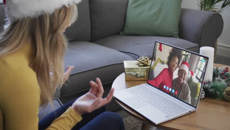 Diverse-mother,-daughter-and-female-friend-having-christmas-laptop-video-call,-slow-motion