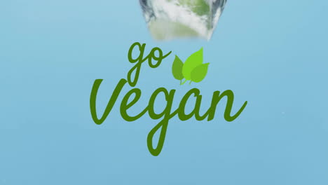 Animation-of-go-vegan-text-over-fruit-falling-in-water-background