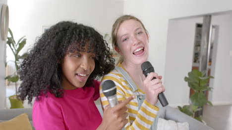 Portrait-of-happy-diverse-teenage-female-friends-dancing-and-singing-at-home,-slow-motion