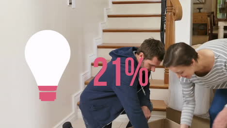 Animation-of-pink-light-bulb-and-percent-over-caucasian-couple-with-boxes-moving-in-to-new-home