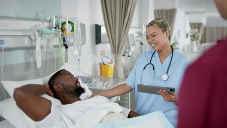 African-american-female-doctor-and-male-patient-talking-in-hospital-room,-slow-motion