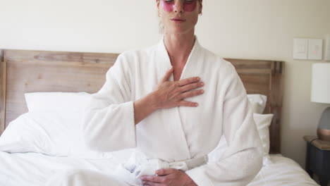Middle-aged-Caucasian-woman-in-a-bathrobe-practices-deep-breathing-at-home