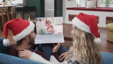 Happy-diverse-couple-and-senior-female-friend-having-christmas-laptop-video-call,-slow-motion