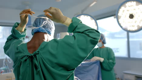 Afroamerikanischer-Chirurg,-Der-Im-Operationssaal-Eine-Gesichtsmaske-Bindet,-Kopierraum,-Zeitlupe