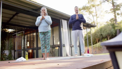 Fokussiertes,-Vielfältiges-älteres-Paar-Praktiziert-Yoga-Meditation-Im-Garten