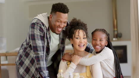 Portrait-of-happy-african-american-parents-and-daughter-embracing-at-home,-slow-motion