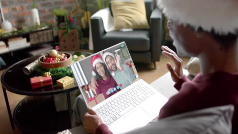 Happy-diverse-couple-and-male-friend-having-christmas-laptop-video-call,-slow-motion