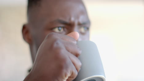 Pensive-african-american-male-soldier-drinking-coffee-and-looking-ahead-in-sunny-room,-slow-motion