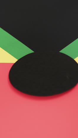 Vertical-video-of-red,-yellow-and-green-papers-with-copy-space-on-black-background