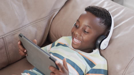 African-American-boy-enjoys-digital-entertainment-at-home-using-a-tablet