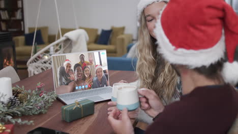 Glückliches,-Abwechslungsreiches-Paar-Und-Gruppen-Von-Freunden,-Die-Zu-Weihnachten-Einen-Laptop-Videoanruf-In-Zeitlupe-Machen