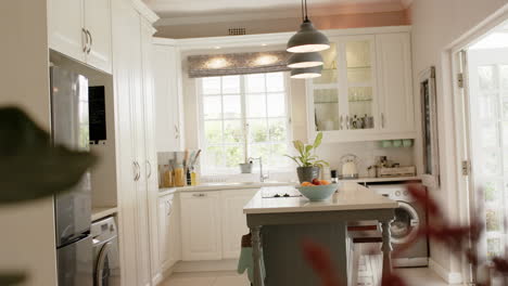 Kitchen-island,-lamps,-furnitures,-fringe-and-windows-in-sunny-kitchen,-slow-motion