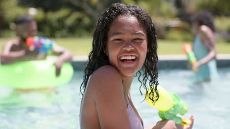 Portrait-of-happy-african-american-daughter-playing-with-family-in-sunny-pool,-slow-motion