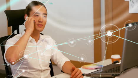 Animation-of-network-of-connections-with-icons-over-asian-businessman-in-office