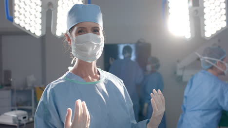 Portrait-of-caucasian-female-surgeon-wearing-surgical-gown-in-operating-theatre,-slow-motion