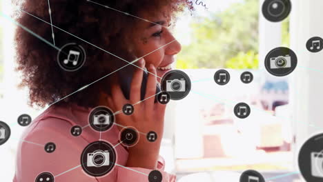 Animation-of-network-of-connected-icons-in-circles-over-african-americanwoman-using-smartphone