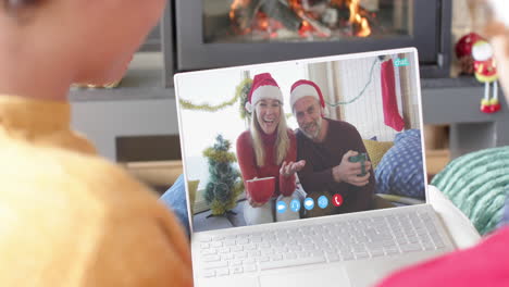 Happy-caucasian-couple-and-male-friends-having-christmas-laptop-video-call,-slow-motion