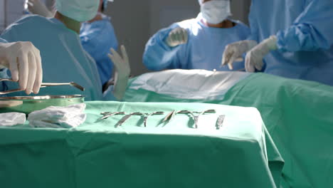 Diverse-surgeons-operating-on-patient-using-surgical-instruments-in-operating-theatre,-slow-motion