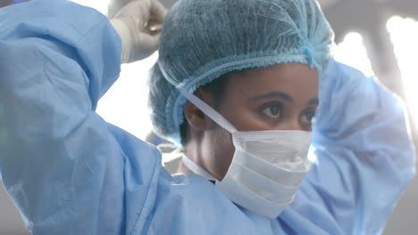 African-american-female-surgeon-wearing-face-mask-in-operating-theatre,-slow-motion