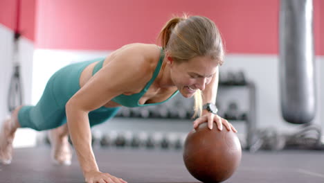 Fit-young-Caucasian-woman-doing-push-up-on-medicine-ball-at-the-gym