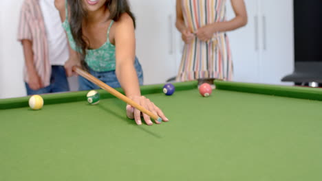 Young-adults-enjoy-a-game-of-pool-at-home,-with-copy-space