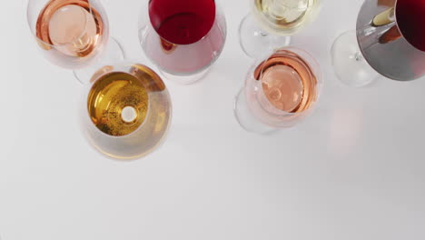 Composite-of-multi-coloured-glasses-with-red,-rose-and-white-wine-on-white-background
