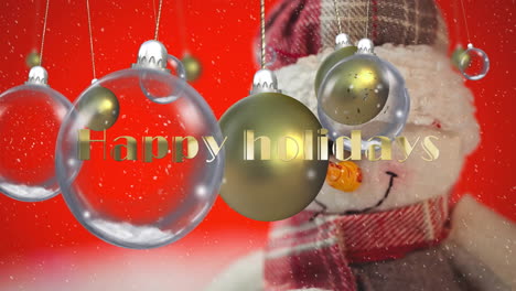Animation-of-happy-holidays-text,-baubles-over-snowfall-on-snowman-against-red-background