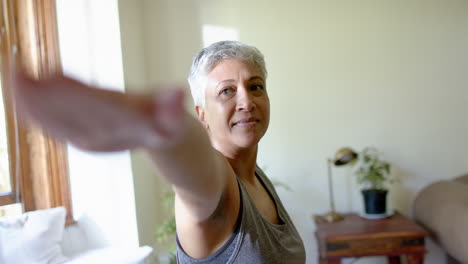 Glückliche-ältere-Frau-Mit-Gemischter-Abstammung,-Die-Zu-Hause-Yoga-Pose-Praktiziert