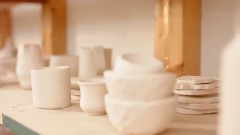 Ceramic-products-lying-on-shelf-in-pottery-studio