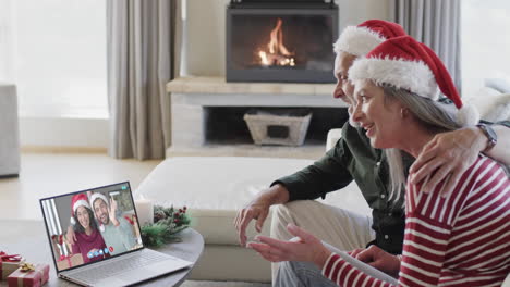 Zwei-Glückliche,-Kaukasische-Paare-Mit-Einem-Weihnachtlichen-Laptop-Videoanruf,-Zeitlupe