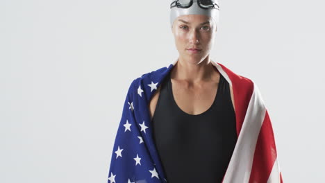 Junge-Kaukasische-Sportlerin-Schwimmerin-In-Einer-Amerikanischen-Flagge-Gehüllt-Steht-Selbstbewusst