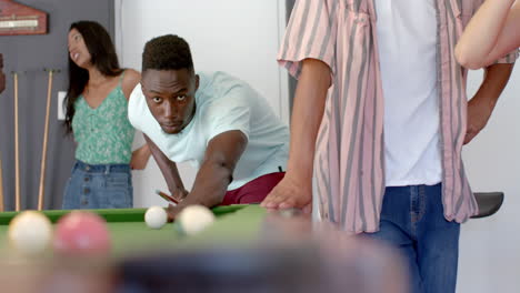 Young-African-American-man-plays-pool-at-a-casual-indoor-gathering
