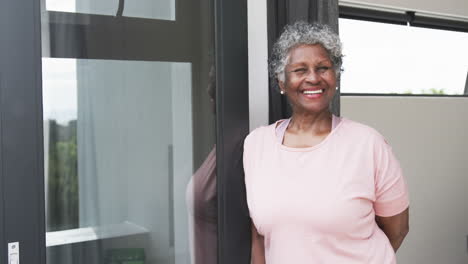 Portrait-of-happy-senior-african-american-woman-smiling-by-window,-copy-space,-slow-motion