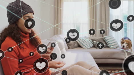 Animation-of-network-of-connected-icons-in-circles-over-happy-biracial-woman-using-smartphone