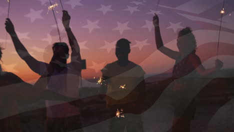 Animation-Der-Amerikanischen-Flagge-über-Fröhlichen,-Unterschiedlichen-Freunden,-Die-Mit-Wunderkerzen-Am-Strand-Bei-Sonnenuntergang-Tanzen