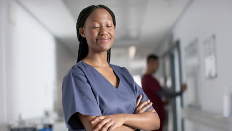 Retrato-De-Una-Feliz-Doctora-Afroamericana-Usando-Batas-En-El-Hospital,-Cámara-Lenta