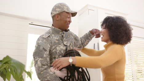 Glücklicher-Afroamerikanischer-Soldat-Umarmt-Seine-Tochter-Und-Seine-Frau-Zu-Hause,-Zeitlupe