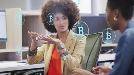 Animation-of-bitcoin-symbols-over-diverse-colleagues-discussing-work-in-office