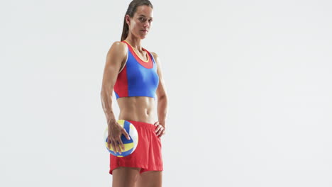 Sportliche-Junge-Kaukasische-Frau-Hält-Einen-Volleyball-Posiert-Selbstbewusst-Auf-Einem-Weißen-Hintergrund,-Mit-Co