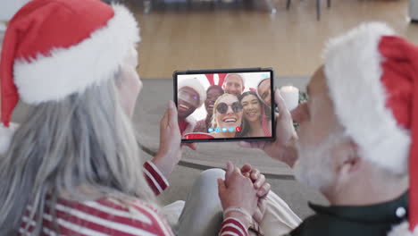 Happy-diverse-senior-couple-and-friends-having-christmas-tablet-video-call,-slow-motion
