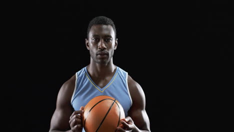 Afroamerikanischer-Mann-Hält-Einen-Basketball-Auf-Schwarzem-Hintergrund